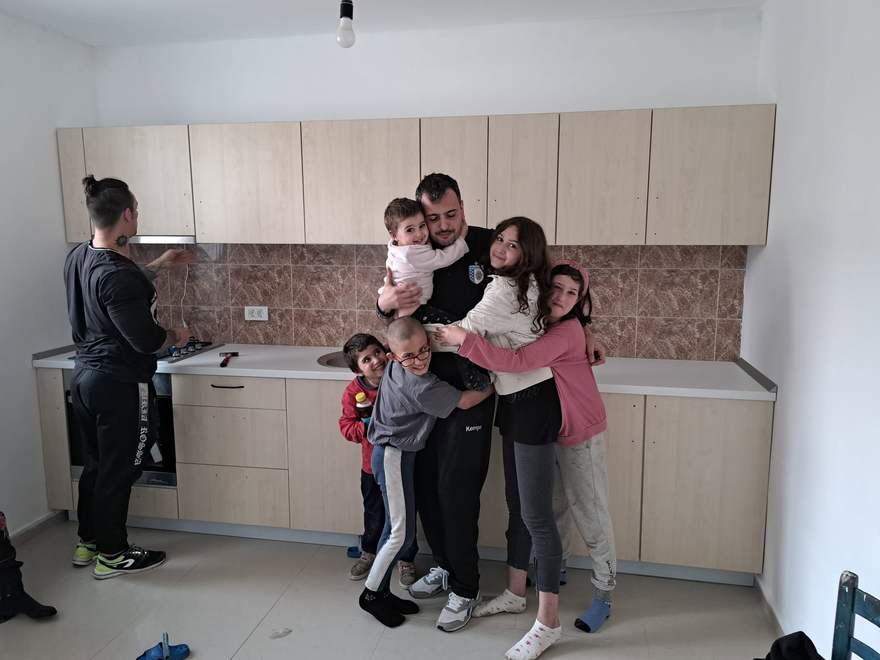 Tatăl familiei Manea, îmbrățișat de toți copiii, în bucătăria complet finalizată