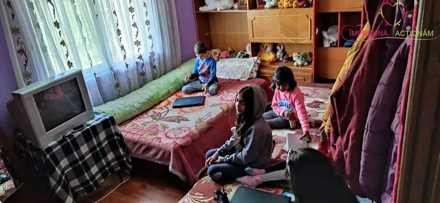 Voluntarii asociației despachetând cutii cu alimente și haine la o familie sprijinită